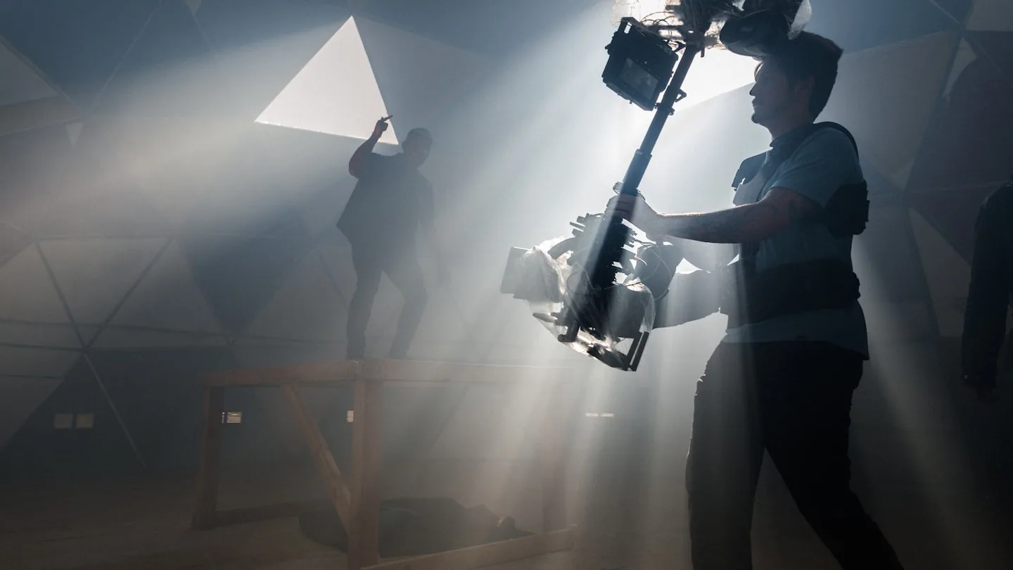 Professional cinematographer with camera equipment in a studio lighting setup